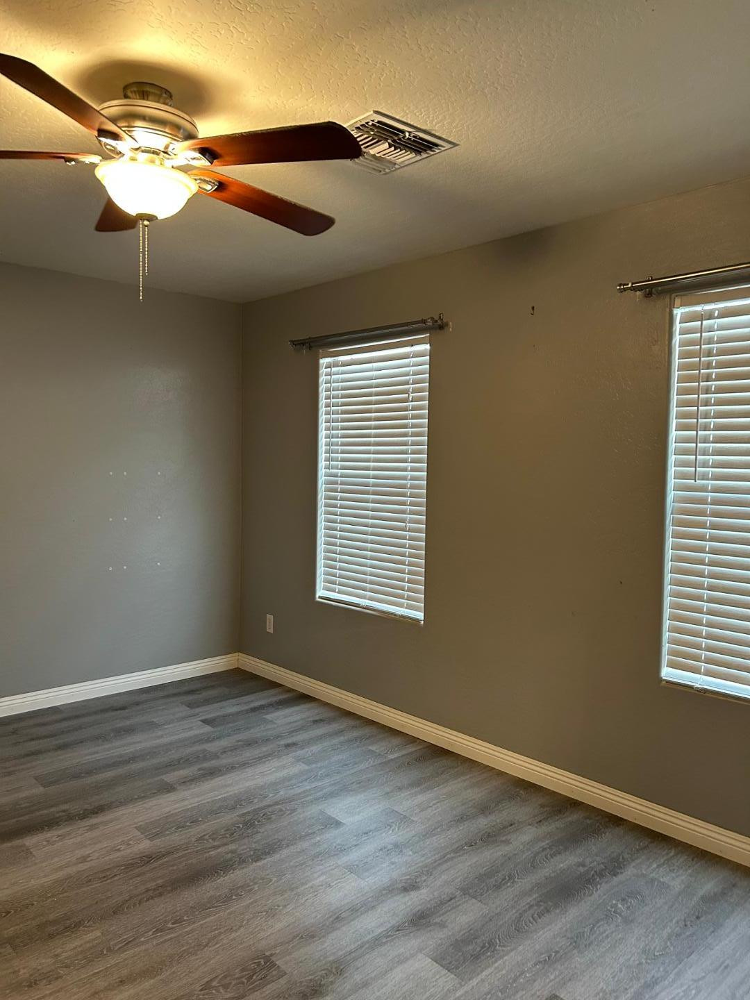 7044 West Alta Vista Road Laveen, AZ 85339 - Photo 4 of 11 a view of an empty room with wooden floor and a window