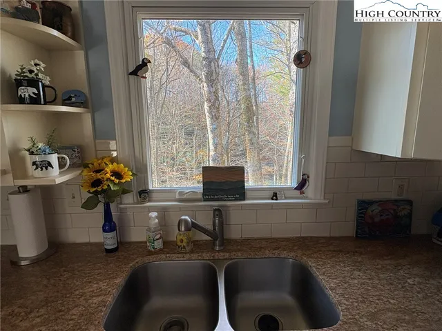 a kitchen filled with a window and chairs