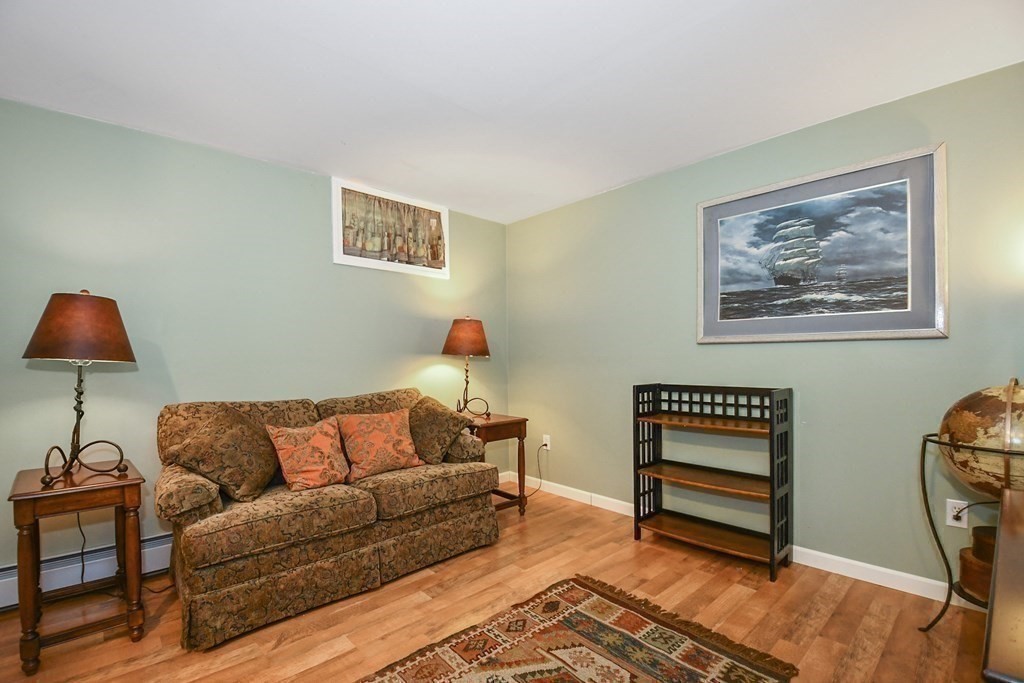 60 Peabody Road, Unit B Shirley, MA 01464 - Photo 23 of 42 a living room with furniture a rug and a wall painting
