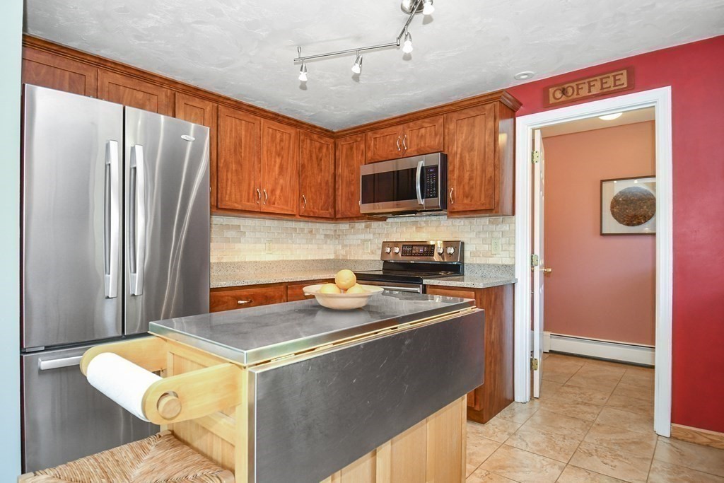 60 Peabody Road, Unit B Shirley, MA 01464 - Photo 26 of 42 a kitchen with stainless steel appliances granite countertop a refrigerator a stove top oven a sink dishwasher and wooden cabinets