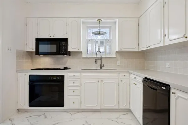 a kitchen with white cabinets and a stove top oven