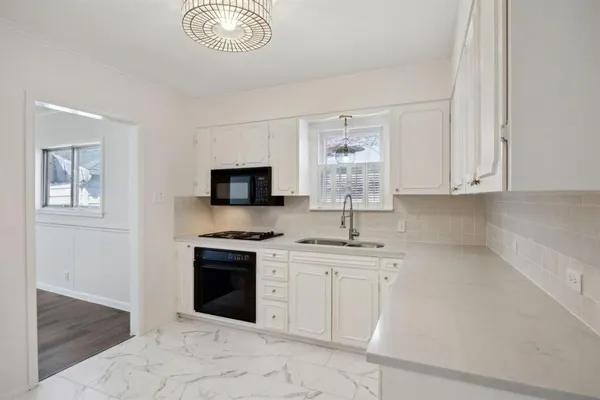 a kitchen with stainless steel appliances granite countertop a stove sink and microwave