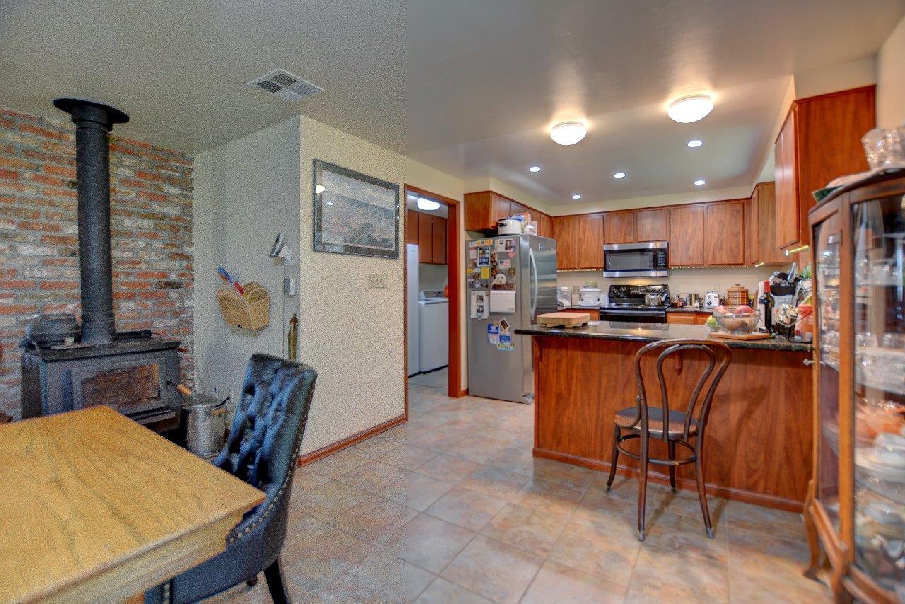 8684 Wagner Creek Road Talent, OR 97540 - Photo 51 of 78 a kitchen with stainless steel appliances wooden floor dining table and chairs