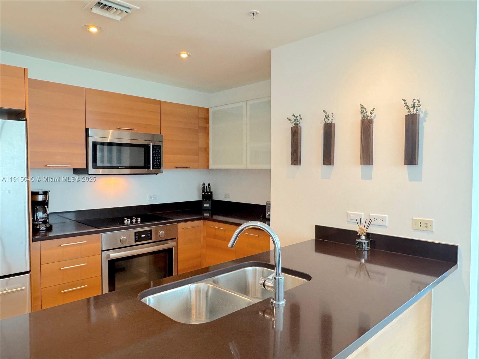 3301 Northeast 1st Avenue, Unit H3001 Miami, FL 33137 - Photo 12 of 53 a kitchen with granite countertop a sink a stove and cabinets