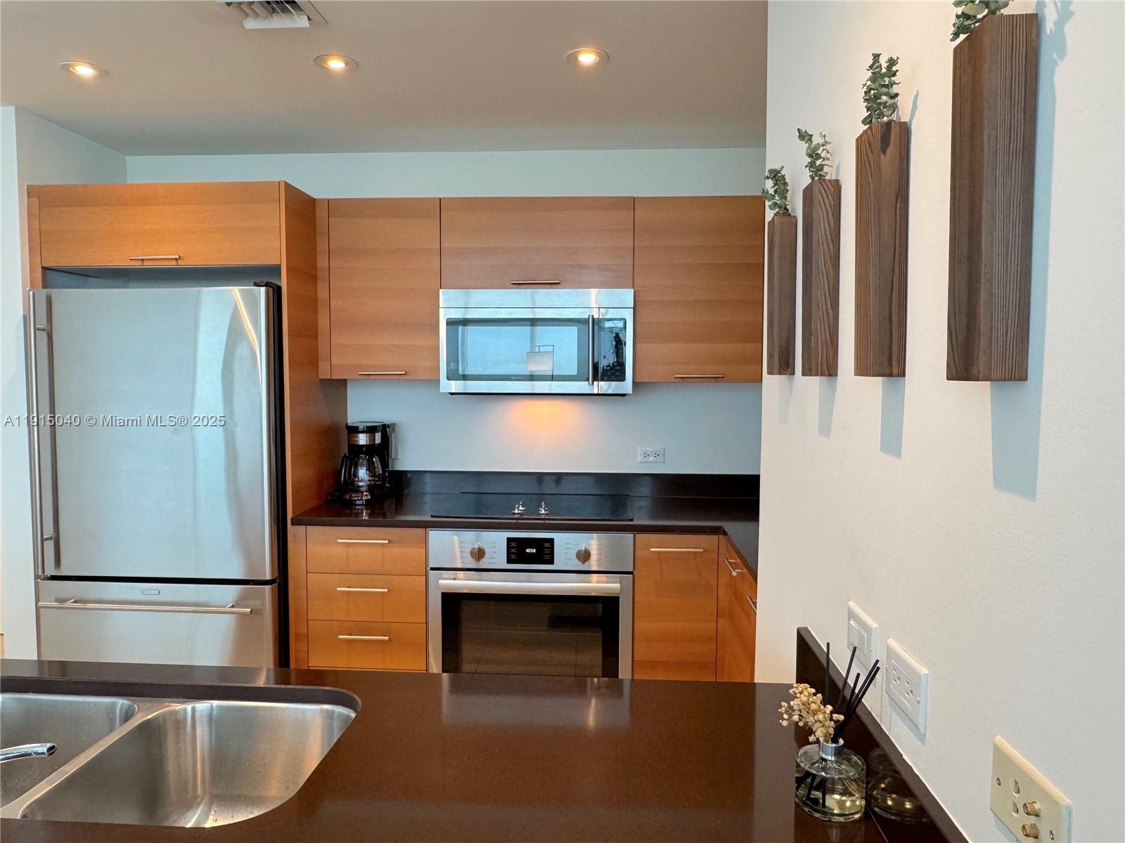 3301 Northeast 1st Avenue, Unit H3001 Miami, FL 33137 - Photo 14 of 53 a kitchen with stainless steel appliances granite countertop a refrigerator and a stove