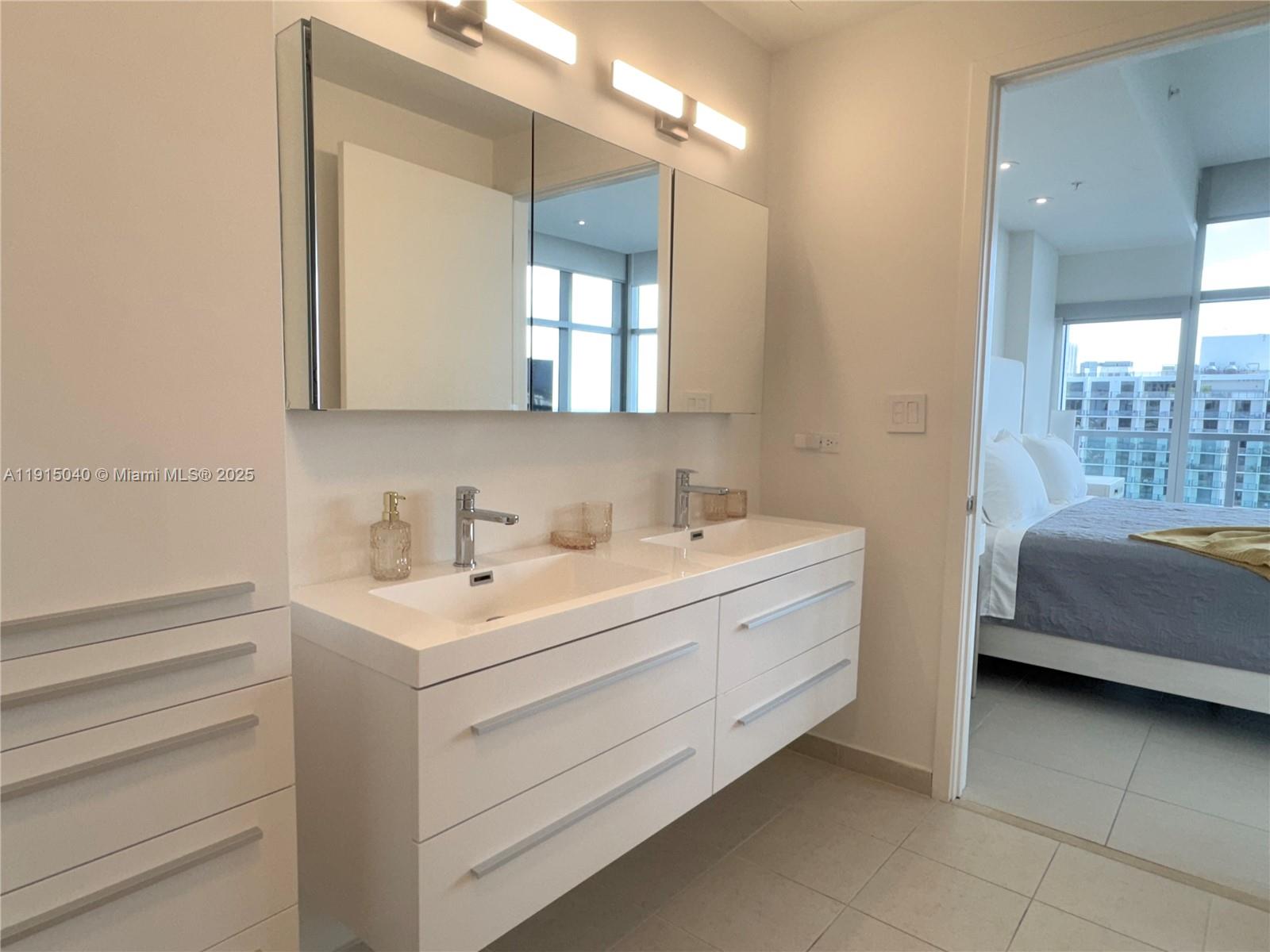 3301 Northeast 1st Avenue, Unit H3001 Miami, FL 33137 - Photo 24 of 53 a bathroom with a double vanity sink a mirror and a bathtub
