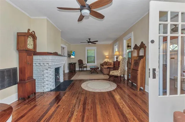 a living room with a fireplace and wooden floor