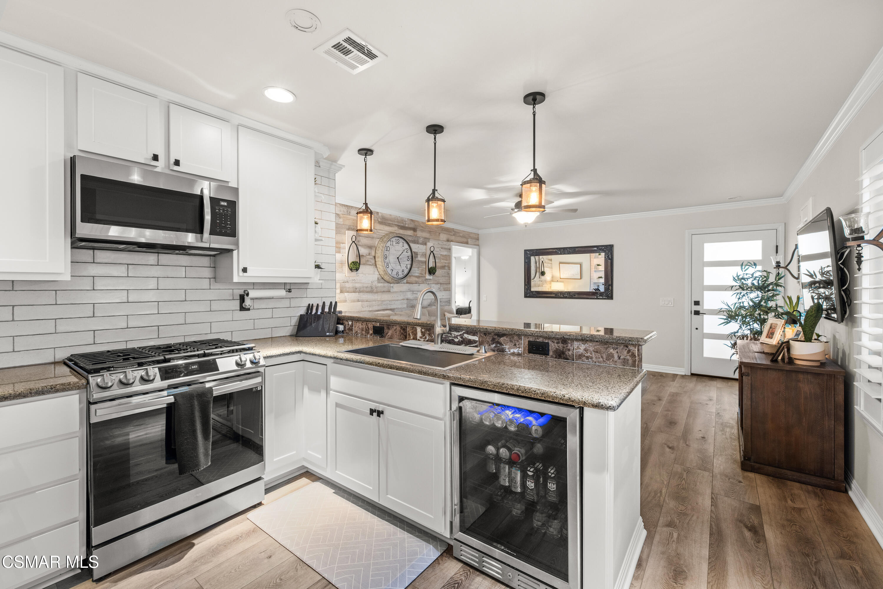 5200 Prairieview Street Camarillo, CA 93012 - Photo 7 of 24 a kitchen with stainless steel appliances granite countertop a stove top oven a sink dishwasher a refrigerator and a dining table with wooden floor