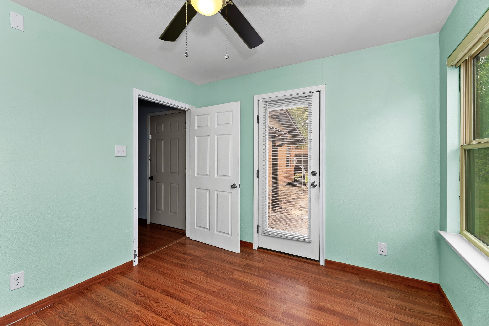 5600 Libyan Circle Austin, TX 78745 - Photo 23 of 37 Unfurnished bedroom with dark wood-style floors, a ceiling fan, and access to exterior