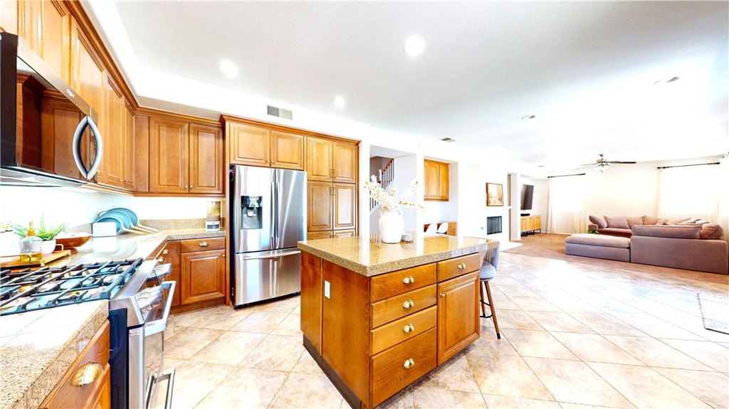 1279 Longbranch Road San Jacinto, CA 92582 - Photo 8 of 35 a kitchen with stainless steel appliances granite countertop a stove refrigerator and dishwasher with wooden floor