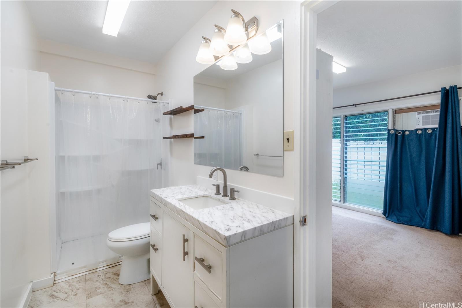 385 Kuliouou Road, Unit A Honolulu, HI 96821 - Photo 8 of 25 a bathroom with a granite countertop sink a toilet and a mirror