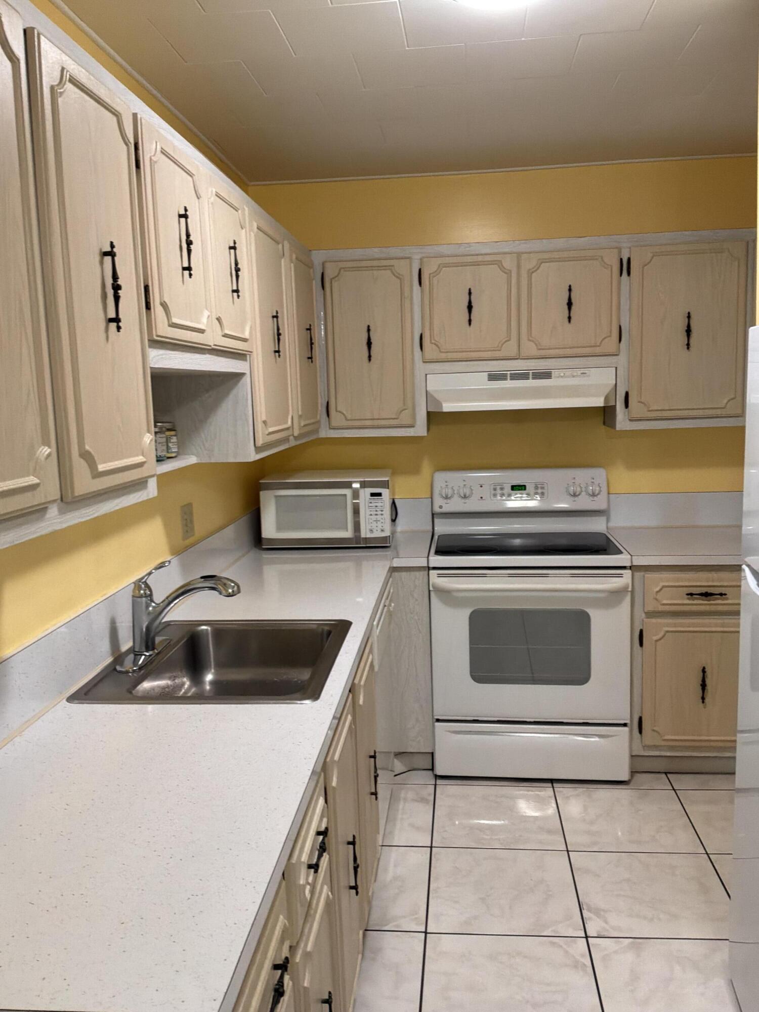 1121 Cactus Terrace, Unit 202 Delray Beach, FL 33445 - Photo 11 of 31 a kitchen with a sink stove and cabinets