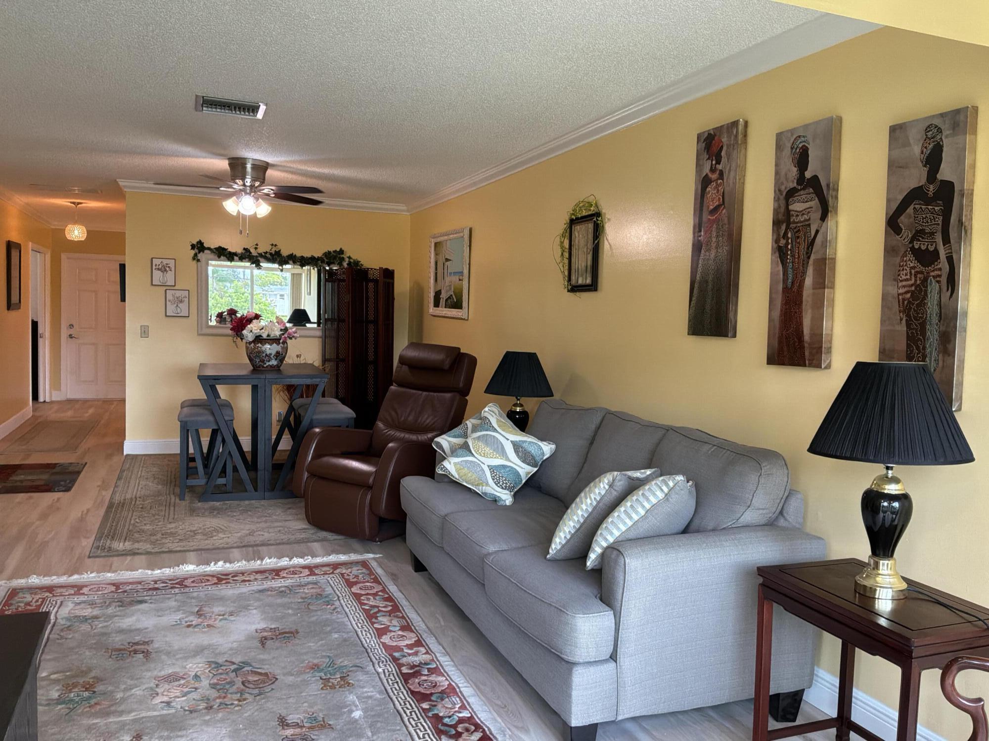 1121 Cactus Terrace, Unit 202 Delray Beach, FL 33445 - Photo 14 of 31 a living room with furniture and a lamp