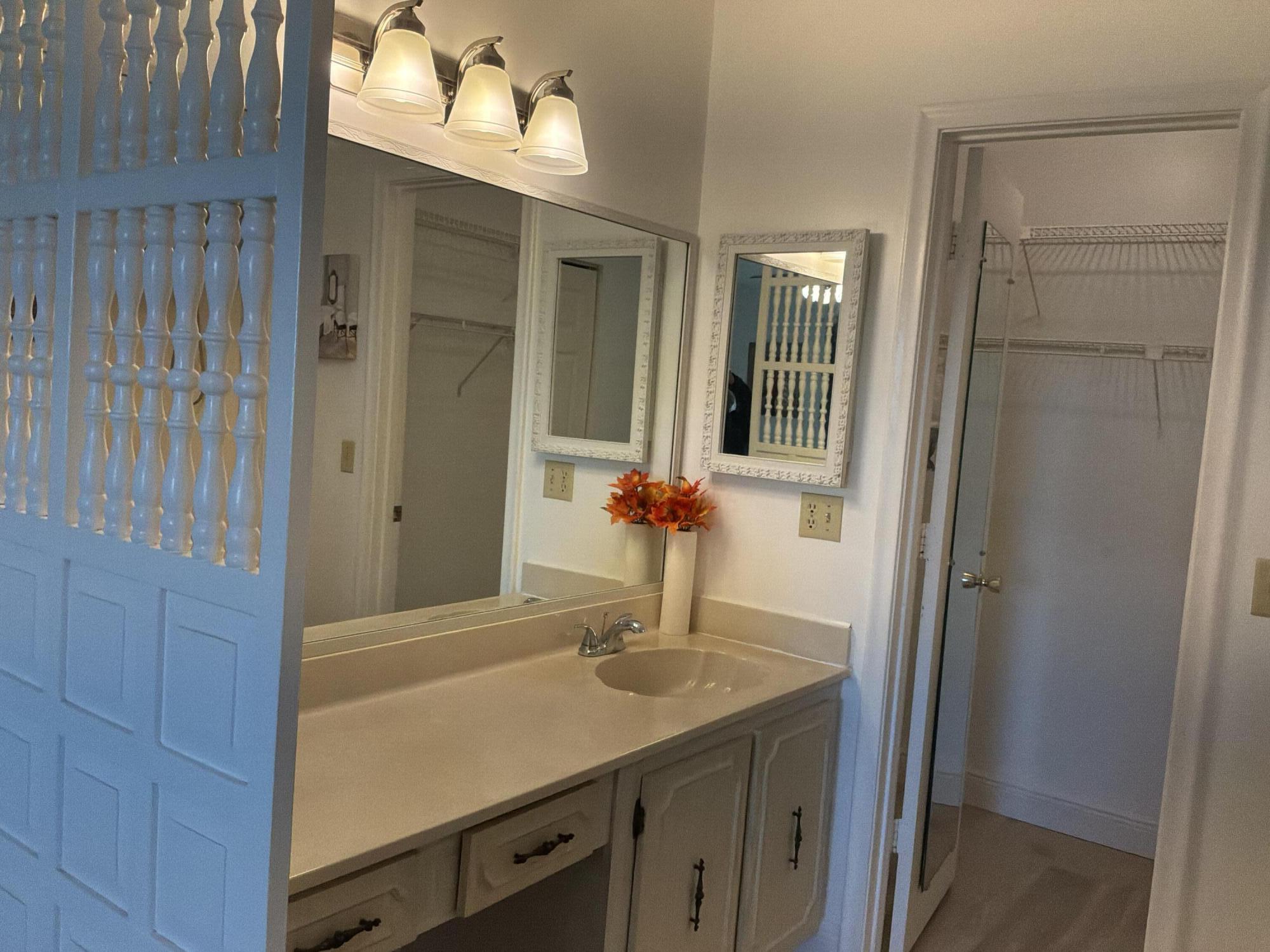 1121 Cactus Terrace, Unit 202 Delray Beach, FL 33445 - Photo 27 of 31 a bathroom with a sink and a mirror
