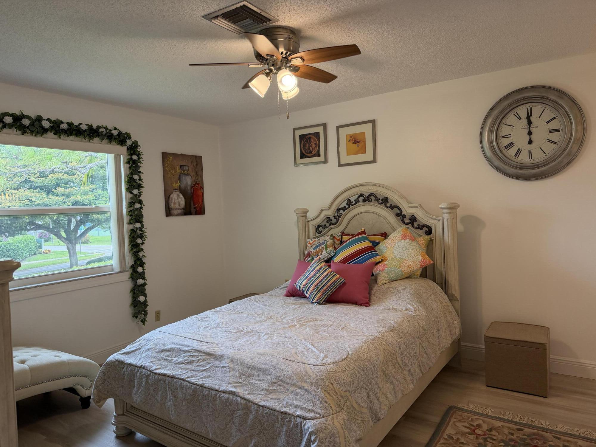 1121 Cactus Terrace, Unit 202 Delray Beach, FL 33445 - Photo 28 of 31 a bedroom with a bed and a chandelier