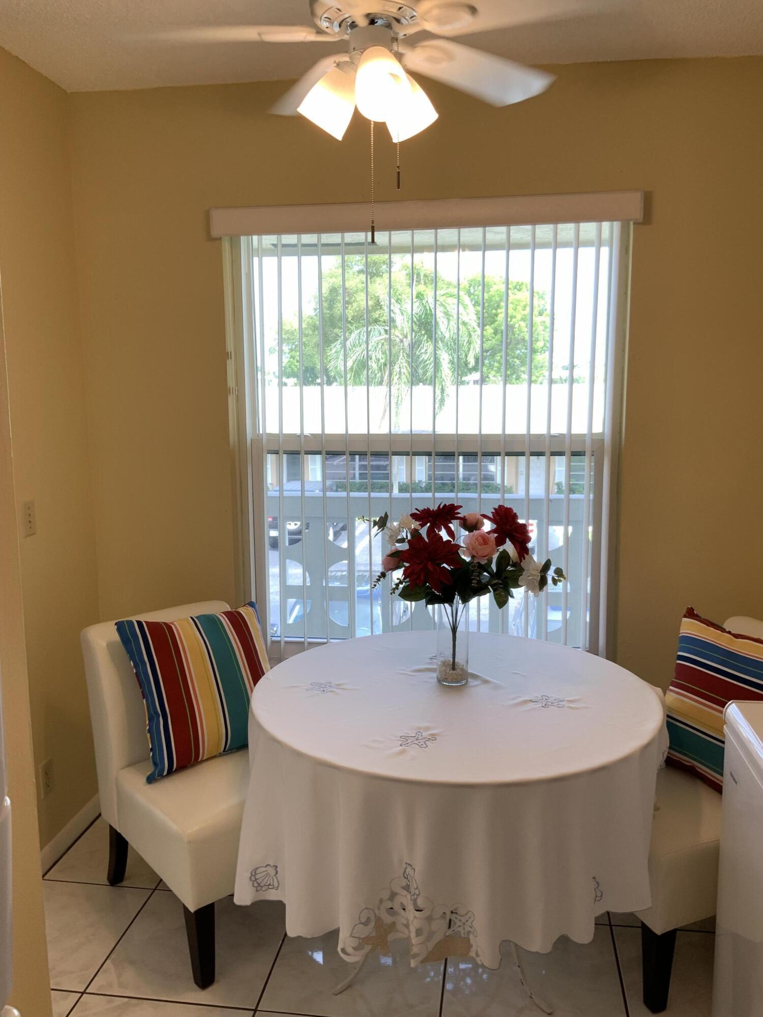 1121 Cactus Terrace, Unit 202 Delray Beach, FL 33445 - Photo 3 of 31 a view of a dining room with furniture and chandelier