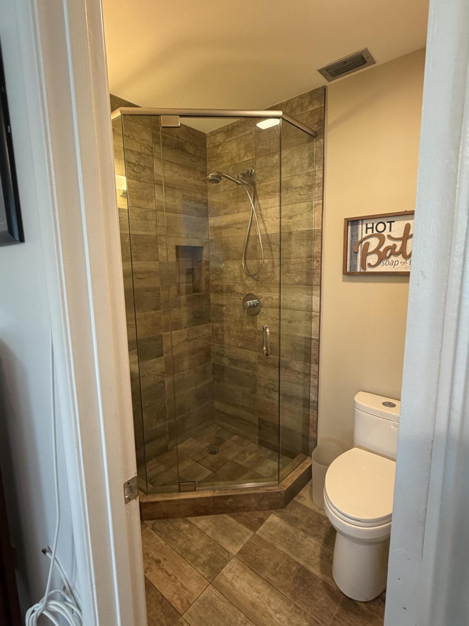 1121 Cactus Terrace, Unit 202 Delray Beach, FL 33445 - Photo 6 of 31 a bathroom with a toilet and a shower