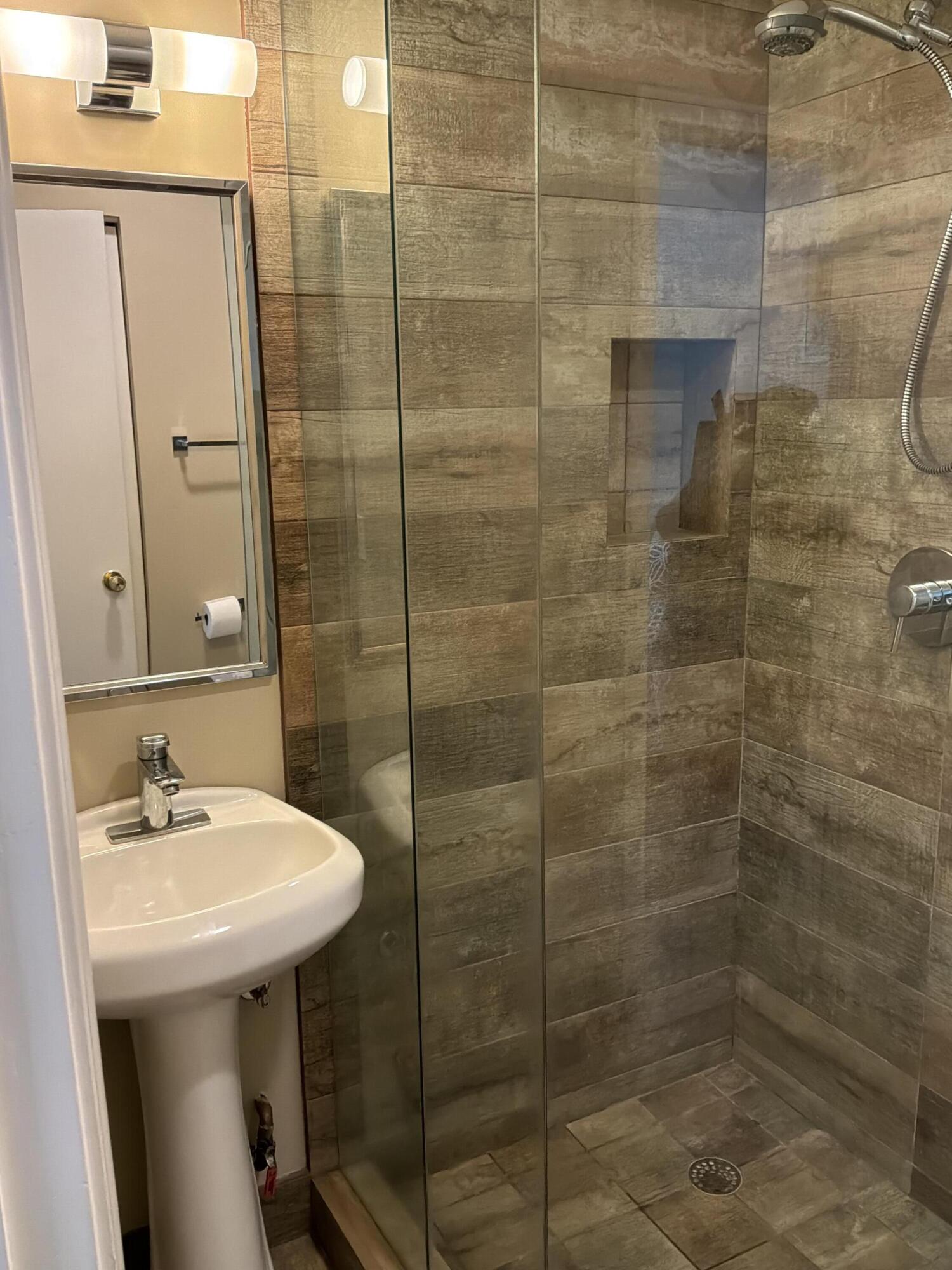 1121 Cactus Terrace, Unit 202 Delray Beach, FL 33445 - Photo 9 of 31 a bathroom with a sink shower and a mirror