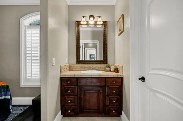 a en suite bathroom with a granite countertop sink a mirror and a vanity