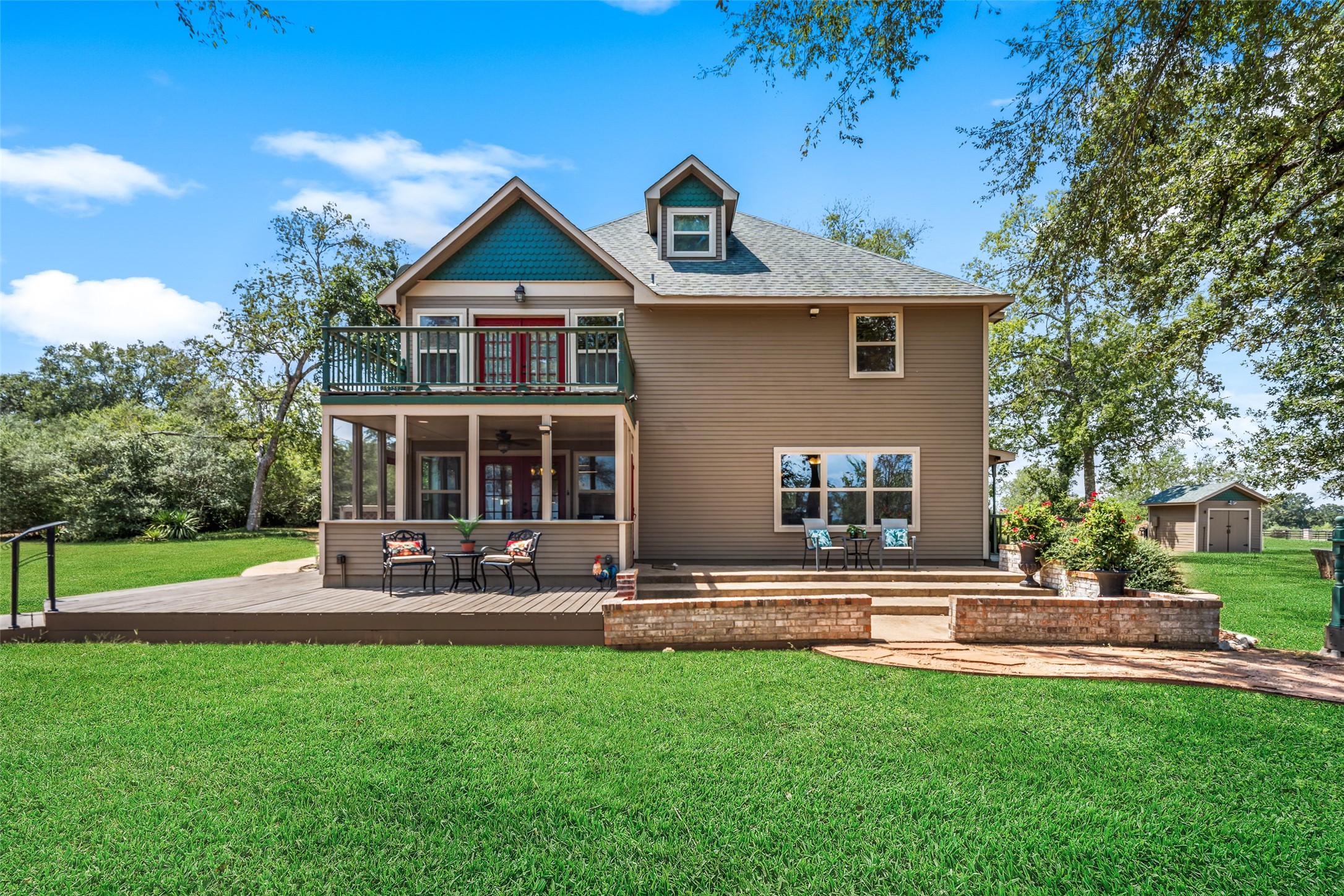 25948 Nelson Road Hempstead, TX 77445 - Photo 32 of 46 Rear exterior view showcasing the home’s multi-level design, covered porch, expansive lawn, and mature shade trees