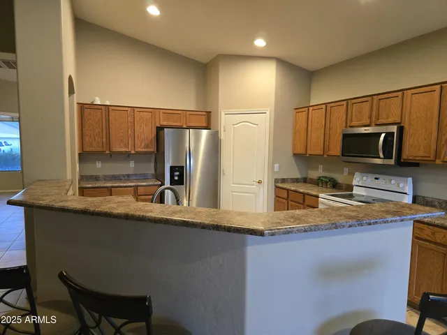 a kitchen with stainless steel appliances granite countertop a sink refrigerator and microwave