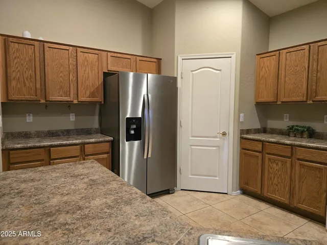 a kitchen with stainless steel appliances granite countertop a refrigerator and a stove top oven