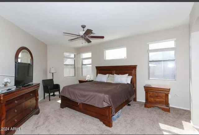 a spacious bedroom with a bed and a flat screen tv
