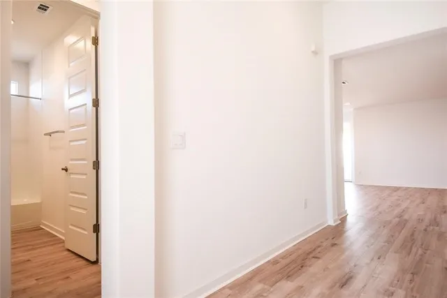 a view of a hallway with wooden floor and a window