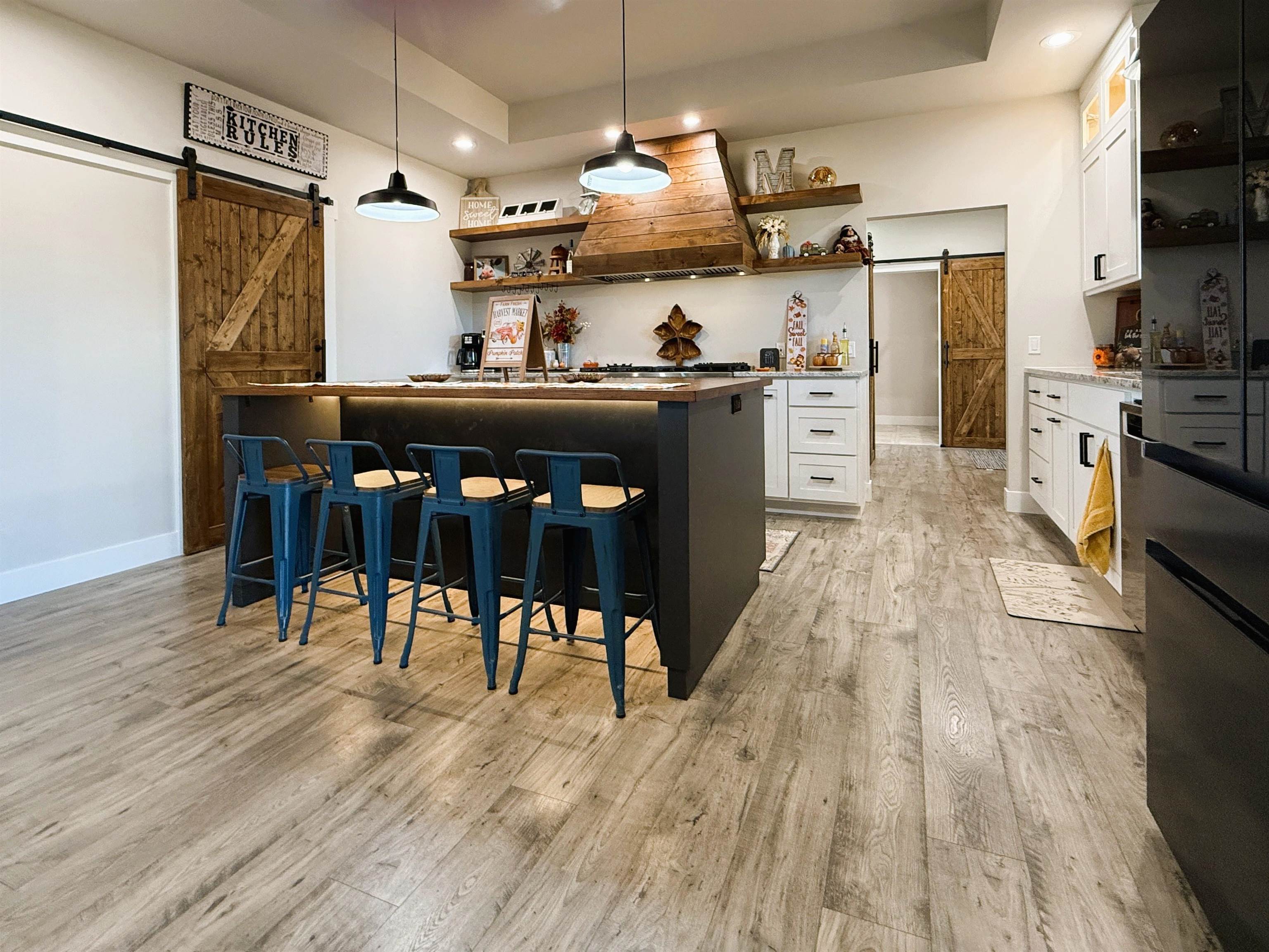 8585 Ellen's Way Austin, CO 81410 - Photo 18 of 42 a kitchen with stainless steel appliances kitchen island granite countertop a table chairs refrigerator and microwave