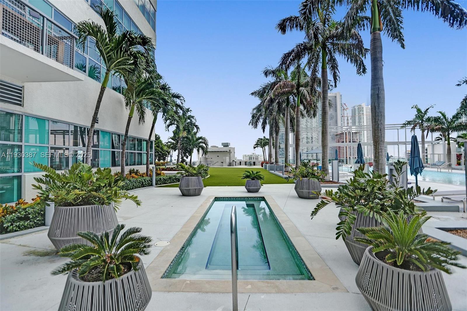 3301 Northeast 1st Avenue, Unit H1105 Miami, FL 33137 - Photo 23 of 34 a swimming pool with potted plants and palm trees