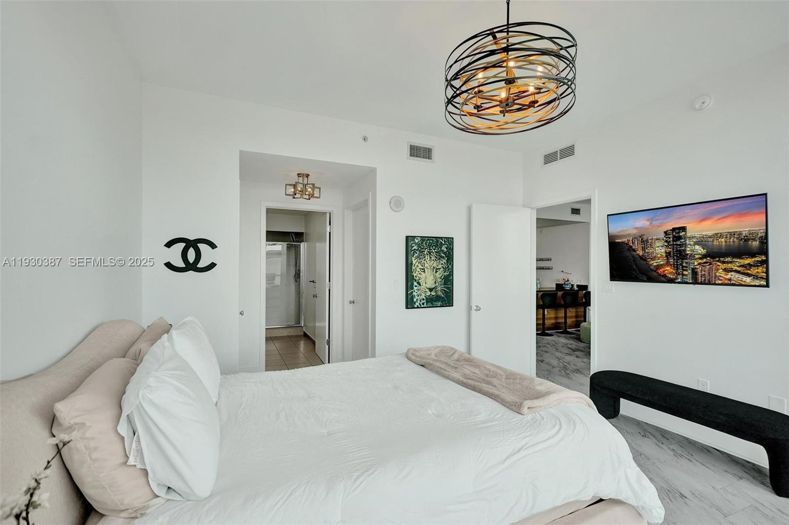 3301 Northeast 1st Avenue, Unit H1105 Miami, FL 33137 - Photo 9 of 34 a bedroom with a bed and a chandelier