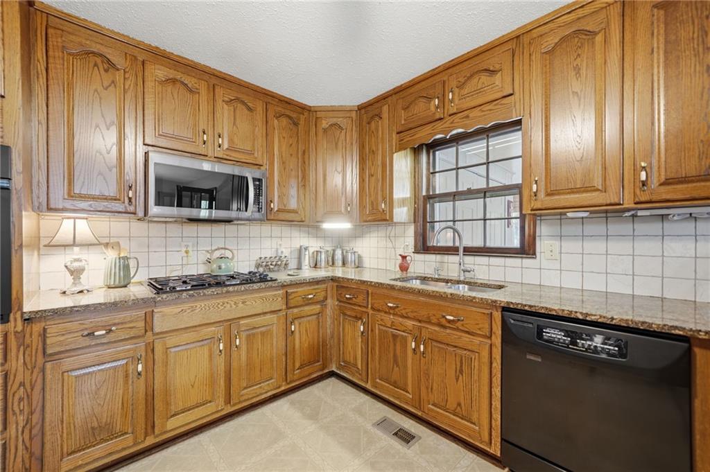 2575 Valleyhill Drive Acworth, GA 30102 - Photo 23 of 48 a kitchen with granite countertop cabinets stainless steel appliances a sink and wooden floor
