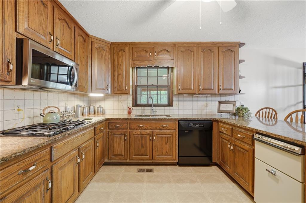 2575 Valleyhill Drive Acworth, GA 30102 - Photo 24 of 48 a kitchen with stainless steel appliances granite countertop a stove sink and cabinets