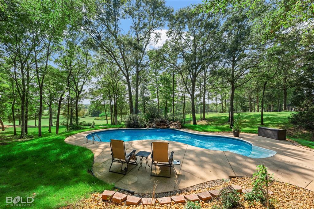 36 Golf Club Drive Haughton, LA 71037 - Photo 30 of 40 a swimming pool with outdoor seating and yard