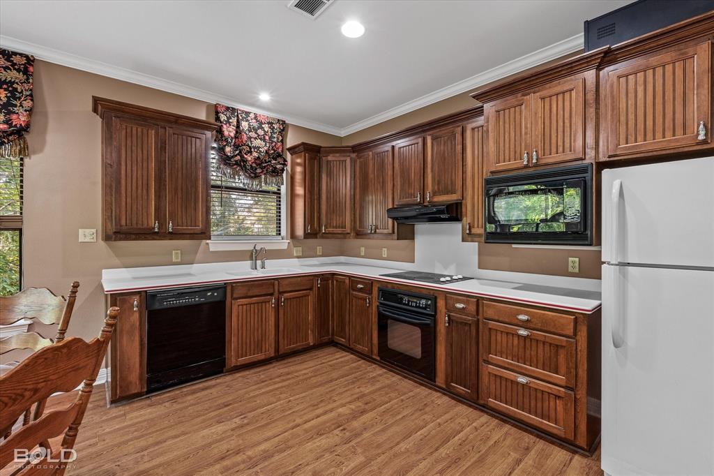 36 Golf Club Drive Haughton, LA 71037 - Photo 35 of 40 a kitchen with stainless steel appliances granite countertop wooden cabinets a sink and a stove