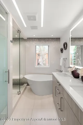 a spacious bathroom with a tub sink and mirror