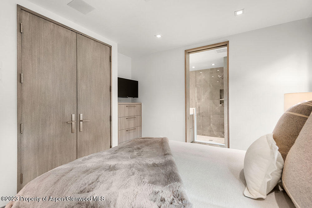 802 East Cooper Avenue, Unit 3 Aspen, CO 81611 - Photo 17 of 28 a bedroom with a bed and a mirror