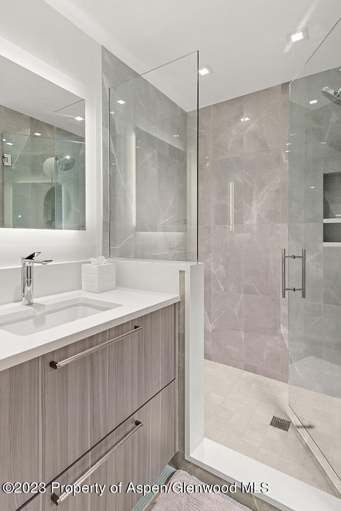 802 East Cooper Avenue, Unit 3 Aspen, CO 81611 - Photo 19 of 28 a bathroom with a bathtub shower sink vanity and mirror