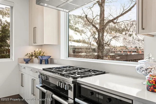a kitchen with a stove a sink and a window