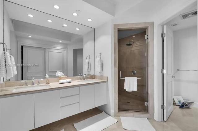 a bathroom with a double vanity sink mirror and shower