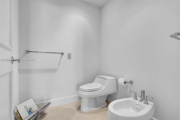 a white toilet sitting next to a white sink and vanity