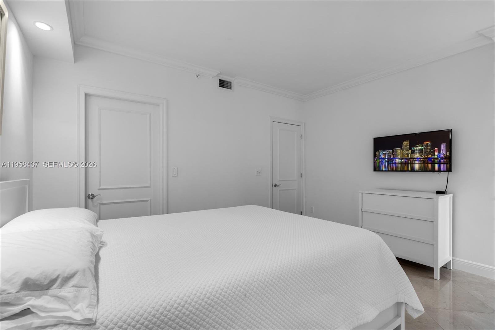 785 Crandon Boulevard, Unit 702 Key Biscayne, FL 33149 - Photo 22 of 41 a bedroom with a bed and a flat screen tv