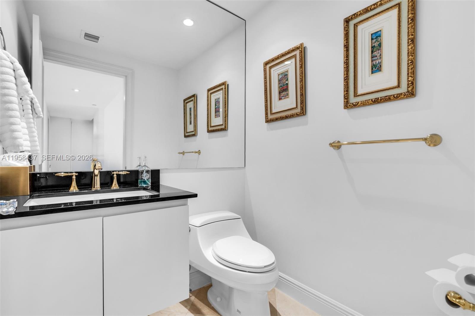 785 Crandon Boulevard, Unit 702 Key Biscayne, FL 33149 - Photo 27 of 41 a bathroom with a toilet sink and mirror