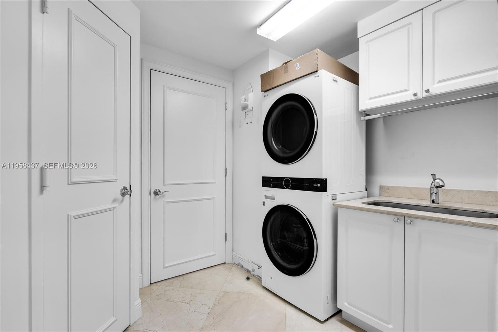 785 Crandon Boulevard, Unit 702 Key Biscayne, FL 33149 - Photo 28 of 41 a utility room with sink dryer and washer