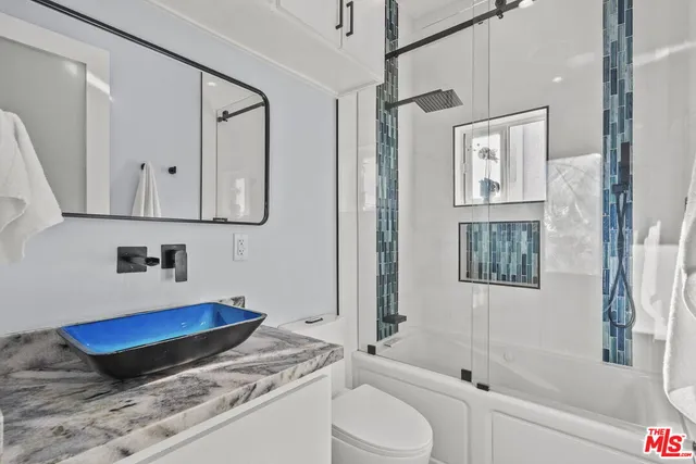 a bathroom with a granite countertop sink mirror vanity and bathtub