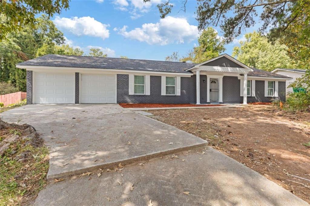 2061 Wellborn Road Lithonia, GA 30058 - Photo 1 of 1 a front view of a house with a yard and garage