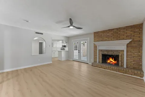 a view of an empty room with a fireplace and a window
