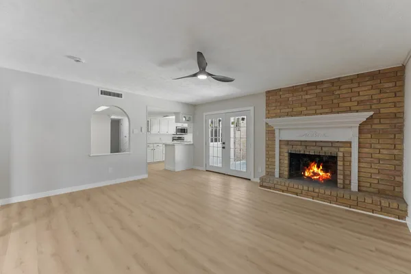 a view of an empty room with a fireplace and a window