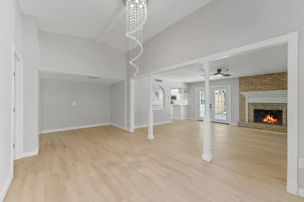 a view of a livingroom with wooden floor and a fireplace