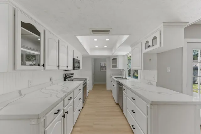 a large white kitchen with stainless steel appliances